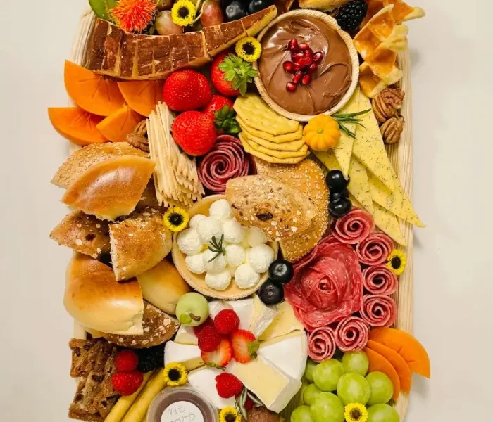 Brunch Board with waffles, Nutella, bagels, cream cheese, 4‑5 cheeses, 2‑3 meats, fresh and dried fruits, crackers, preserves and nuts on a 12×22” bamboo tray — $250 menu item from Shawna Cheeseboards in Reno NV