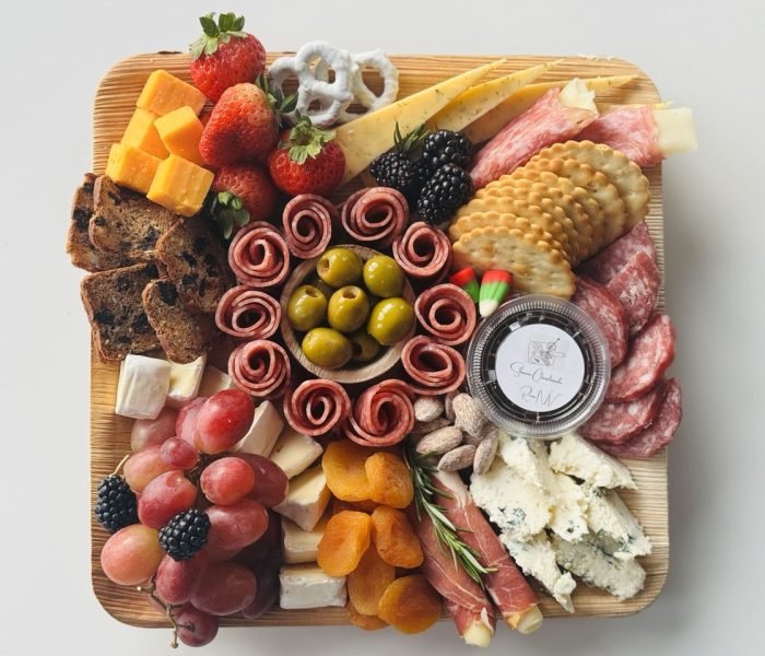 The Medium charcuterie board with 3 cheeses, 2 meats, honey or jam, fresh and dried fruits, nuts, chocolate and crackers on a bamboo tray — $70 menu item from Shawna Cheeseboards in Reno NV