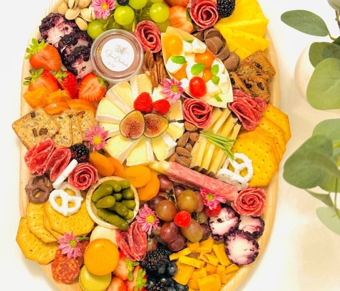 It’s Party Time charcuterie board with 4‑5 cheeses, 2‑3 meats, honey or jam, fresh and dried fruits, nuts, olives, pickles, chocolate and crackers on a 12×17” bamboo tray — $150 menu item from Shawna Cheeseboards in Reno NV